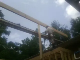 Carpenter setting a ridge beam over a new addition frame — Ice Dam Removal by Roofing Brothers in Old Forge