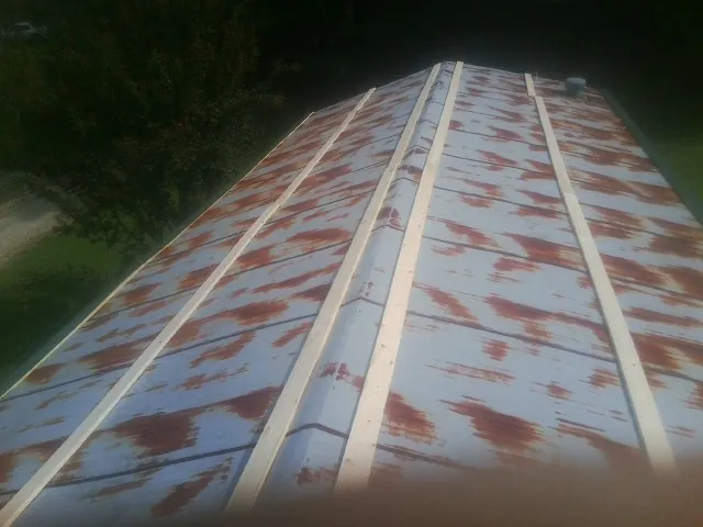 Rusted metal roof panels with new wood purlins before replacement — Storm Damage Roof Repair in Old Forge by Roofing Brothers