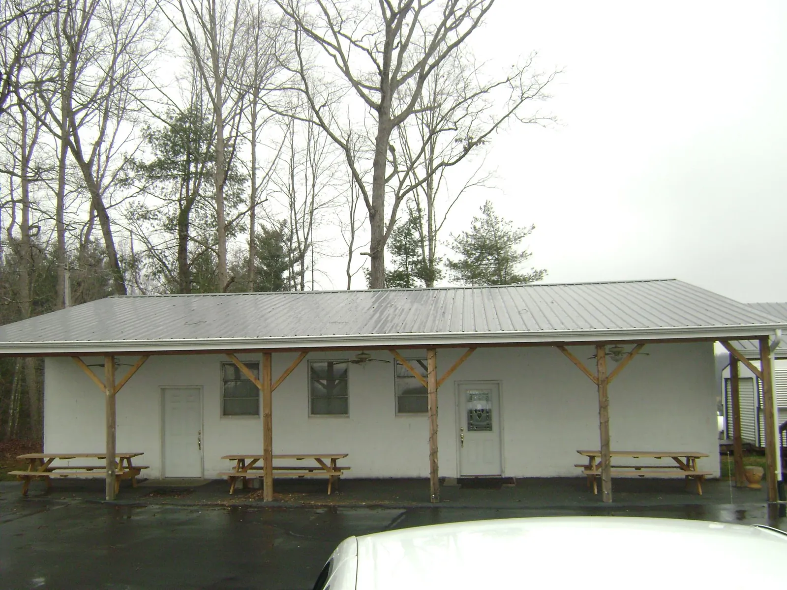 Gray metal roof over a block building with a timber post porch in Old Forge