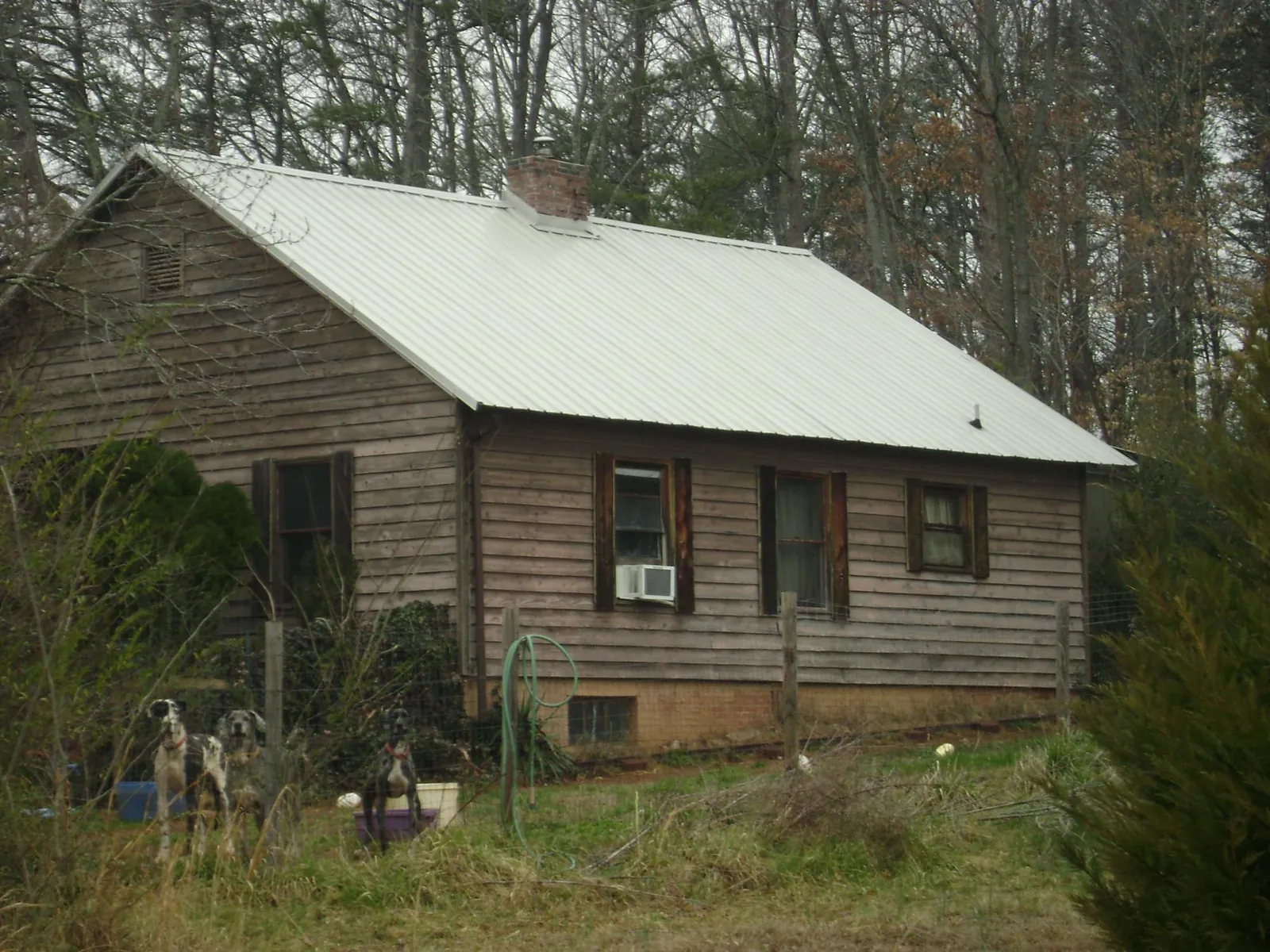 White metal roof on an old wood sided farmhouse, from a Metal Roof Installation job in Old Forge